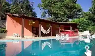 Sítio Três Ipês - Temporada e Eventos. Amplo espaço coberto de churrasqueira, cozinha com geladeira, fogão e microondas, varanda com fogão de lenha e uma ótima área de lazer com piscina..
